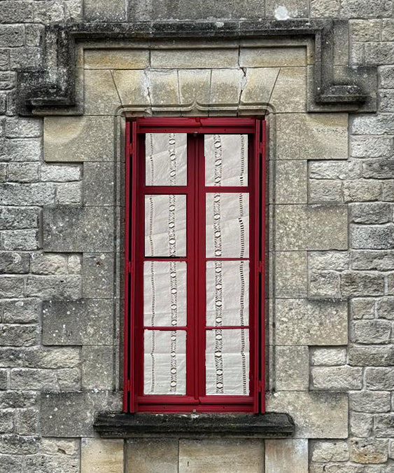 Cortina de hilo y algodón con con vainicas anchas tipo “frailes amarrados” bordadas, terminación recta.