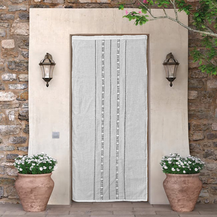 Cortina de hilo y algodón con con vainicas anchas tipo “frailes amarrados” bordadas, terminación recta.