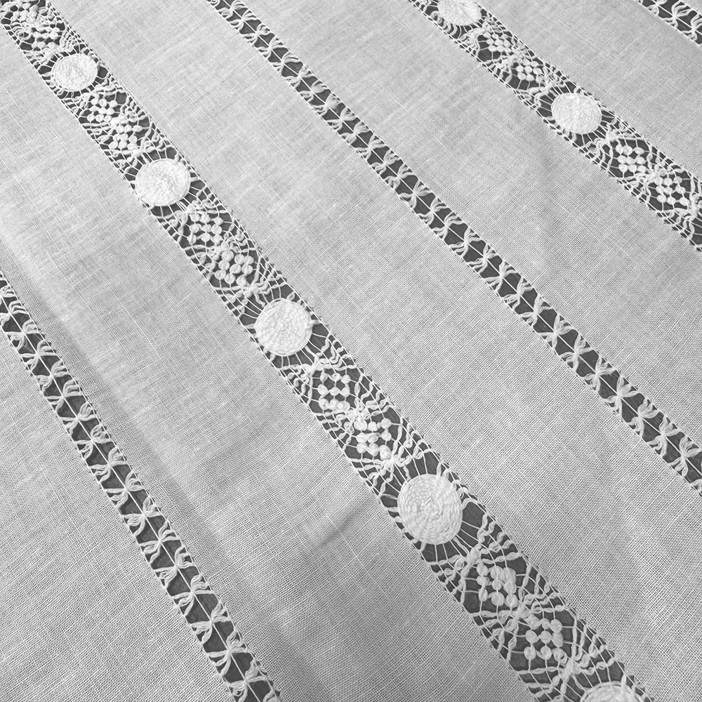 Cortina de hilo y algodón con con vainicas anchas tipo “frailes amarrados” bordadas, terminación recta.